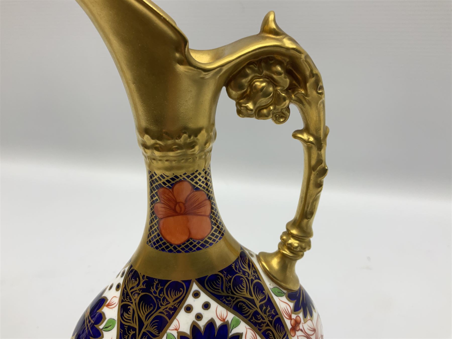 Pair of mid 20th century Royal Crown Derby Imari 1128 pattern Kedleston ewers, each with gilt scroll handle and neck, upon a gilt quatrefoil foot, each with printed marks beneath, H25.5cm