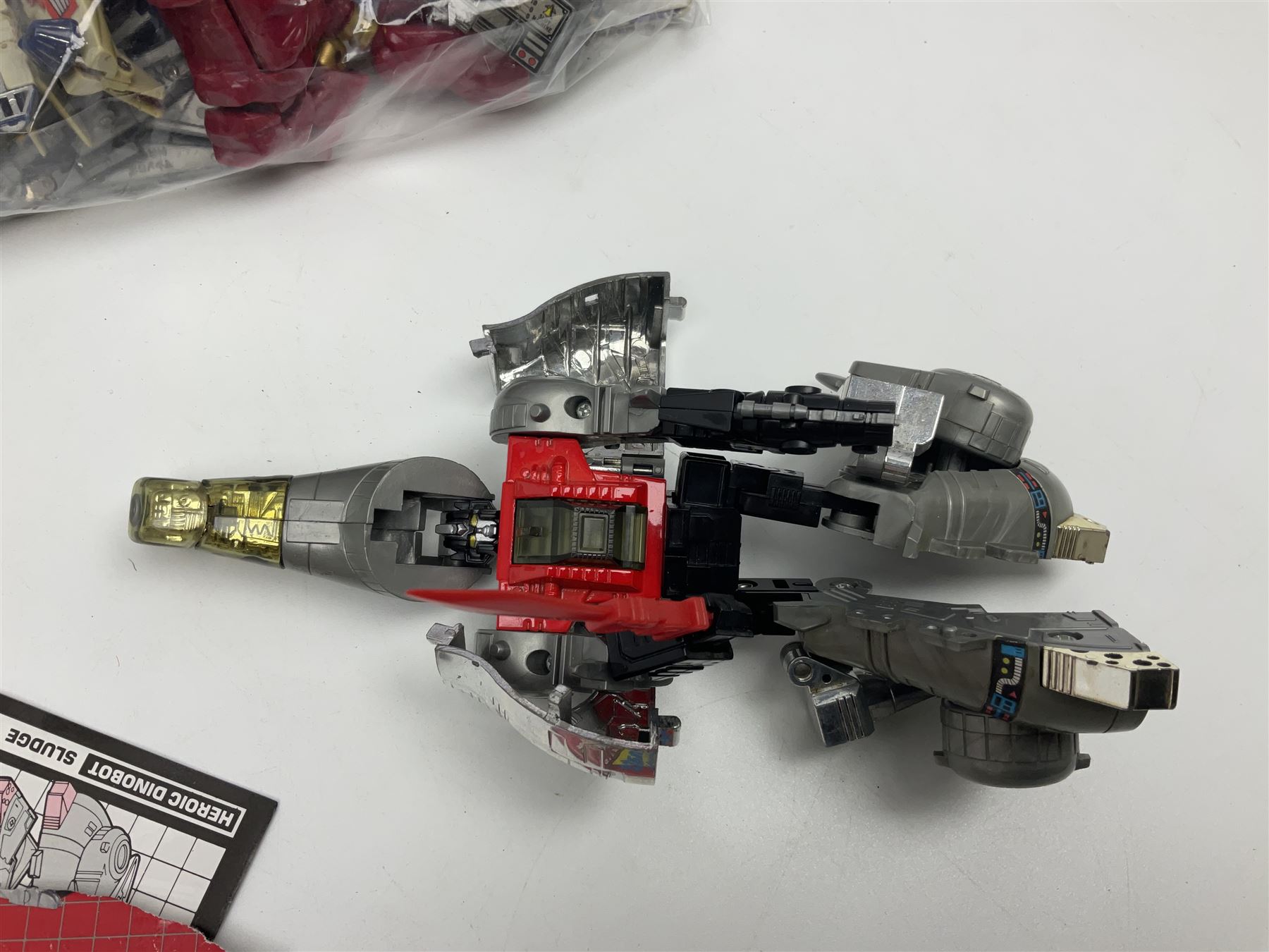 Four 1980sTransformer G1 - Optimus Prime 1984; DinoBot Sludge (Diplodocus) 1984; Cyclonus 1986; and Runamuck 1986; with paperwork; seven Bandai Robo Machines Robots/Transformers; almost fully stocked Panini Sticker album; two annuals; three comics; two posters; and Ladybird story book