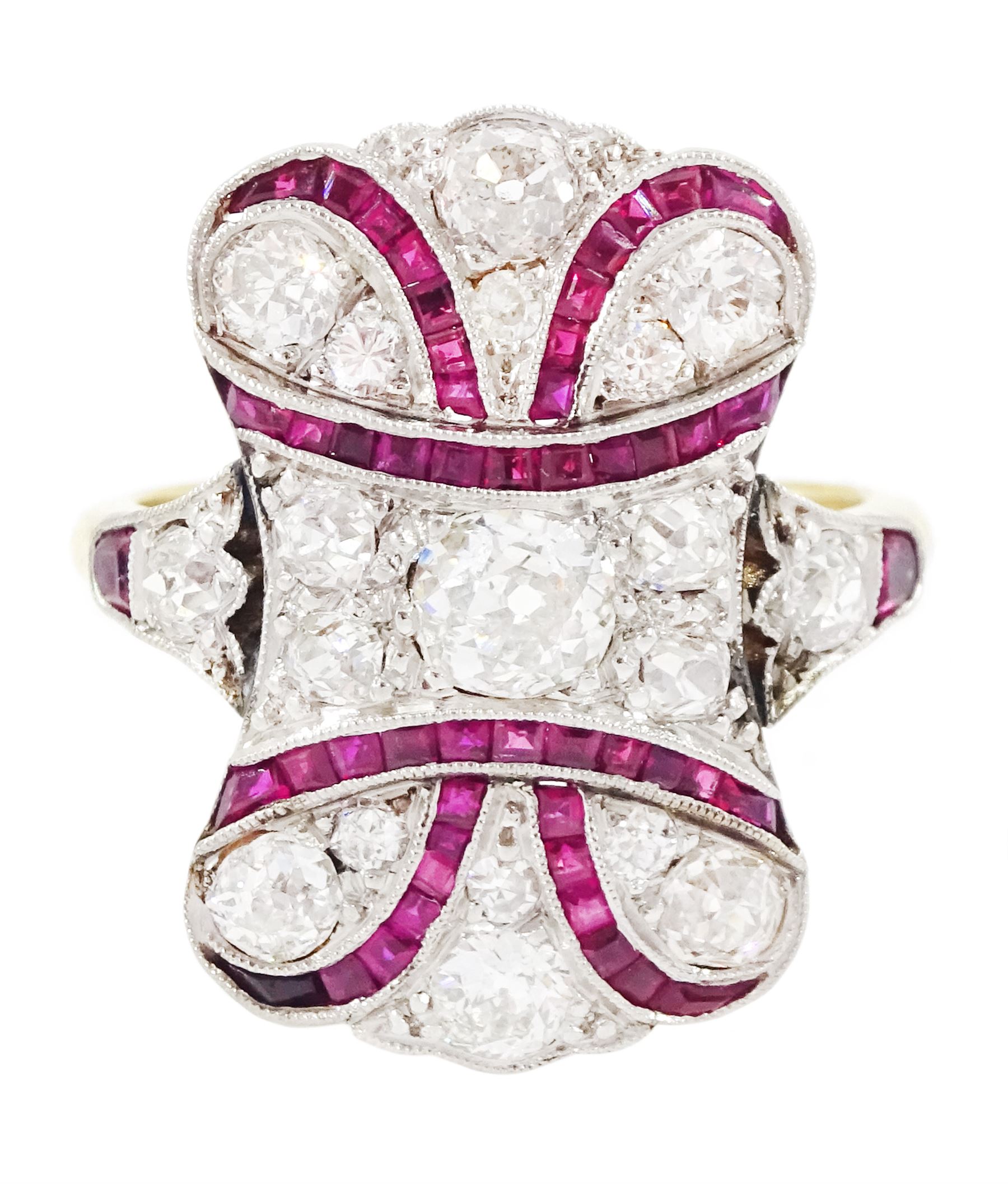 Early 20th century gold and platinum ruby and diamond panel ring, the principal old cut diamond of approx 0.30 carat, with old cut diamond surround and milgrain set calibre cut ruby ribbon motif, the tulip head shoulders set with a further diamond and ruby, total diamond weight approx 1.75 carat