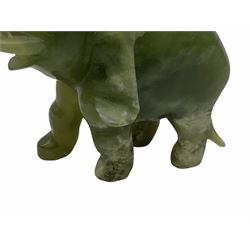 Pair jade figures modelled as elephants with trunks raised, with accompanying carved and pierced wooden stands, figures H9cm 
Provenance: purchased Hong Kong in the 1980s