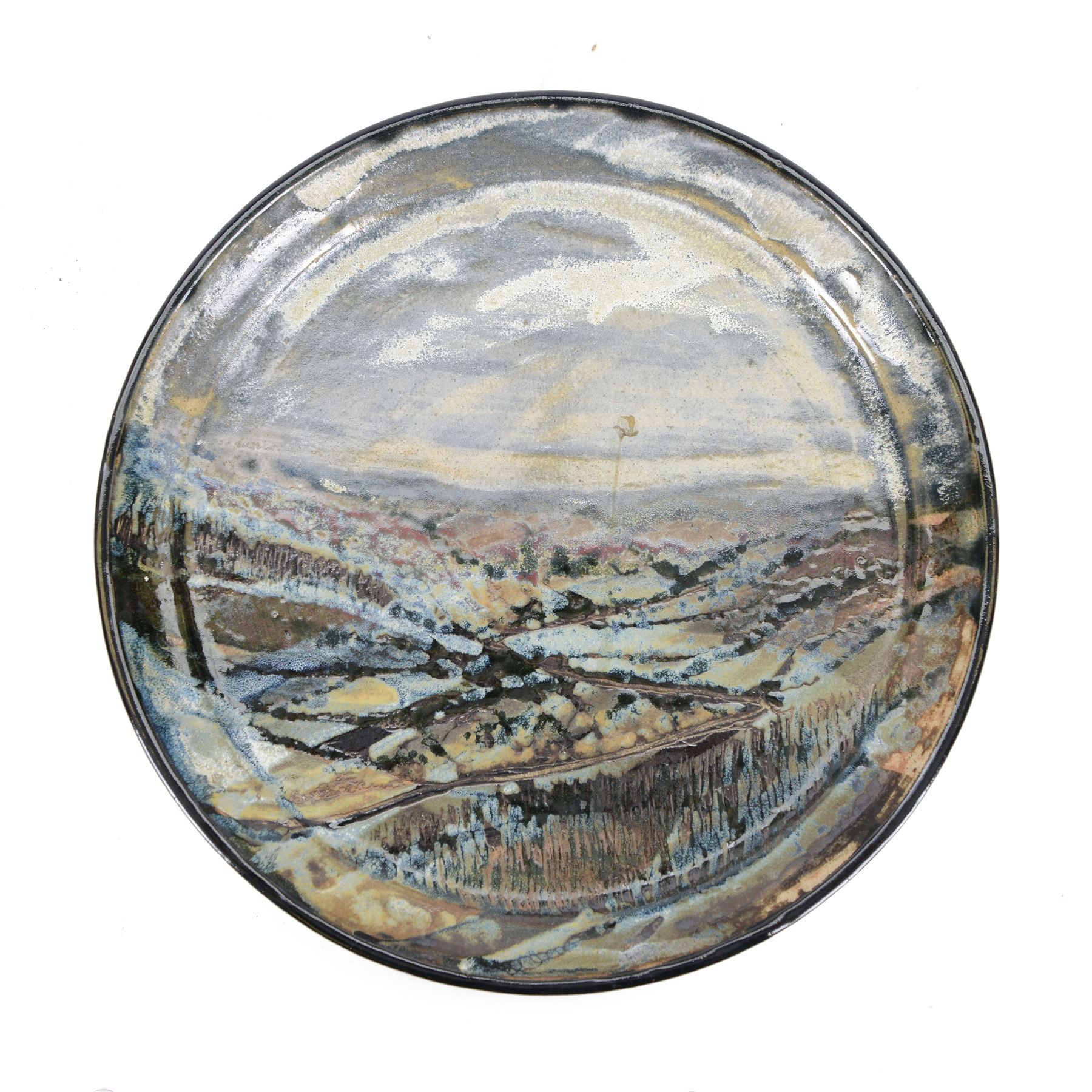 John Egerton (c1945-2024): studio pottery charger, decorated with a moorland view D32cm