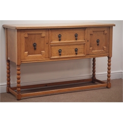  Early 20th century light oak sideboard, two drawers flanked by two cupboards, on bobbin, supports joined by square stretchers, W137cm, H86cm, D46cm  