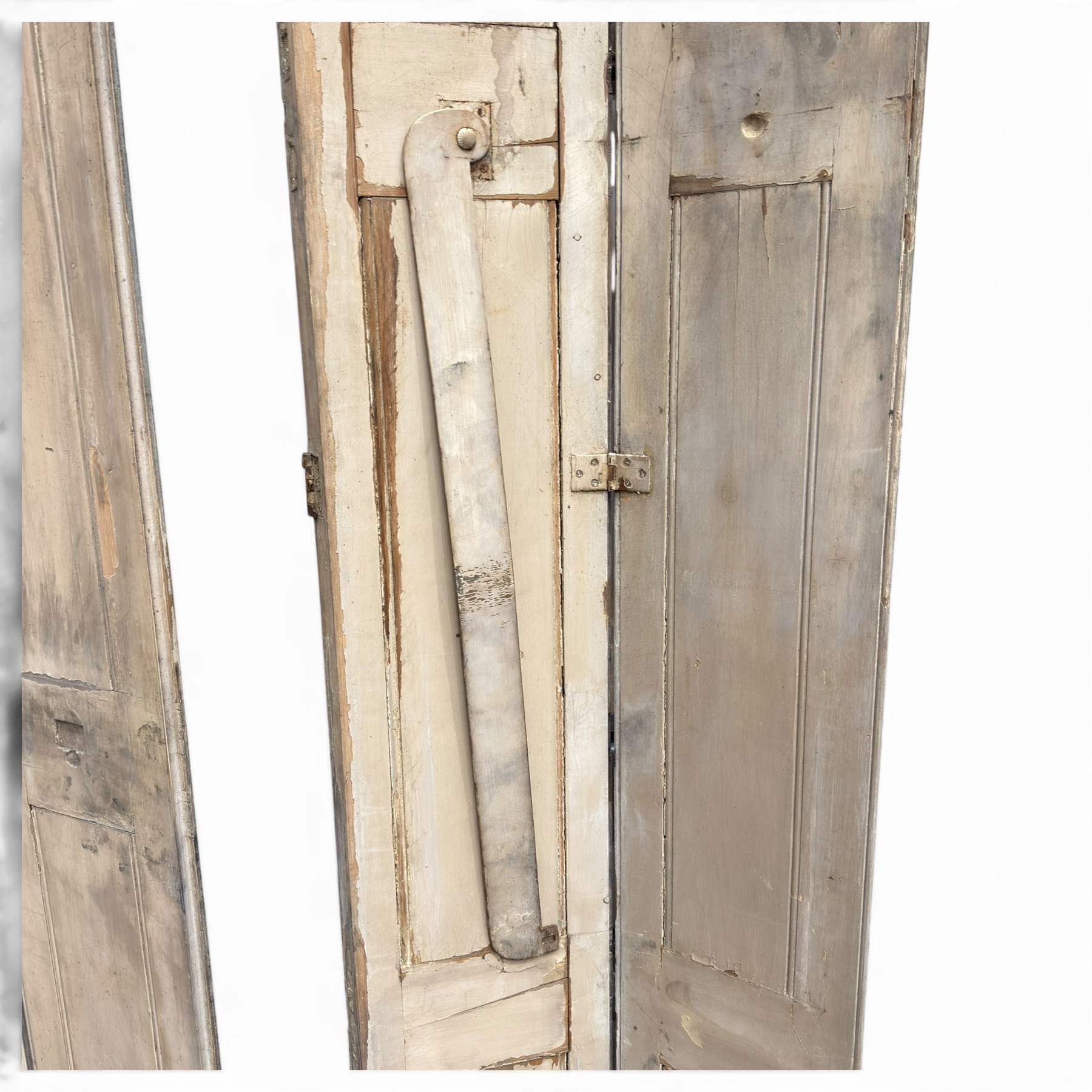Set of three French 19th century painted pine folding window shutters of tall form, each comprising two hinged leaves with three graduated raised and fielded panels, in antique cream-painted finish