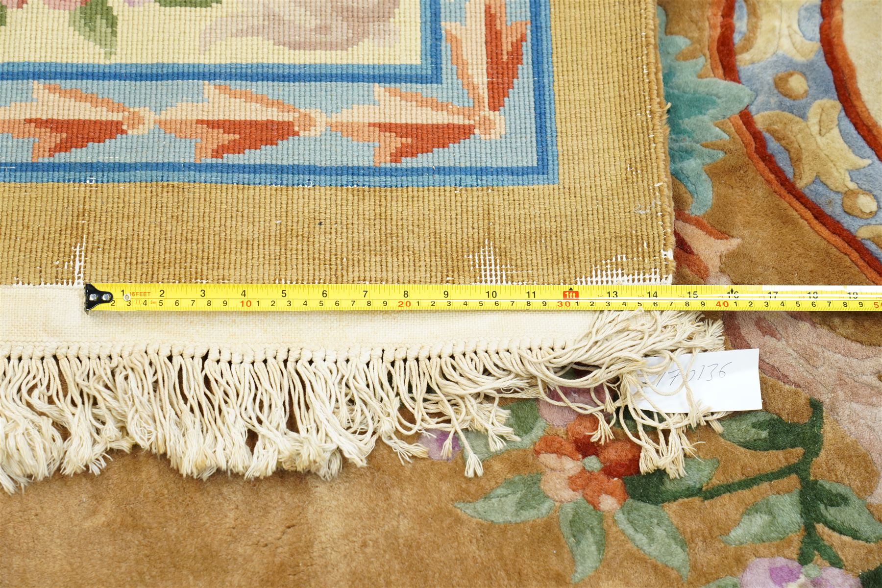 Chinese Aubusson/Savonnerie style hand-knotted carpet, ivory field with a central oval medallion issuing with stylized bouquets in shades of blush pink, pale blue, sage and green, enclosed by ribbon-tied floral garlands and conforming borders within narrow guard stripes, with cotton fringe ends 