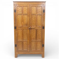 Acornman - oak adzed panelled double wardrobe, with wrought iron hinges and carved oak latch revealing a single clothes rail, with signature carved acorn to top left, by the workshop of Alan Grainger, Brandsby
