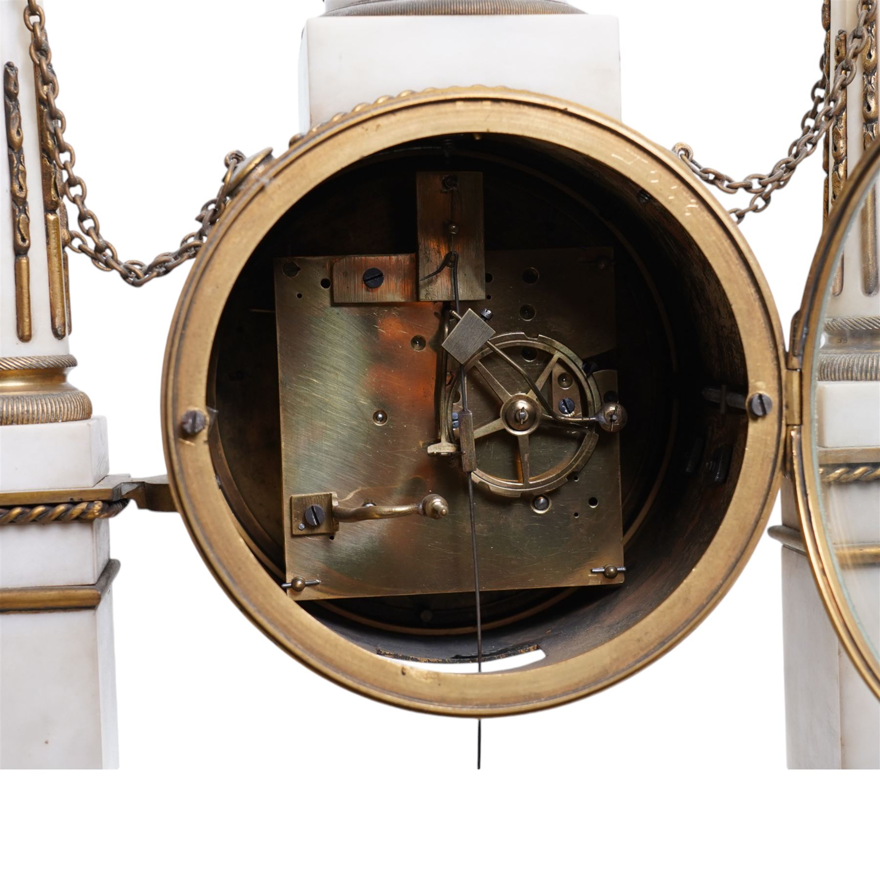 Chevallier of Paris - An early 19th century French Louis XV style white marble and gilt mounted portico clock surmounted by a figure from classical antiquity, with a drum case supported on a pair of reeded and tapered supports with celestial finials raised on a rectangular plinth base, with a white enamel dial with Roman numerals, five minute Arabic's, minute track and makers name,  8-day twin train countwheel movement with a silk suspension, striking the hours and half hours on a bell. 
With pendulum.