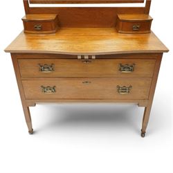 Manner of Liberty & Co. - Arts & Crafts oak dressing chest, the arched swing mirror with roundel-carved frieze and bevelled plate, serpentine-front top with two raised trinket drawers, fitted with two drawers with brass Art-Nouveau poppy handle-plates, on square tapering supports with castors