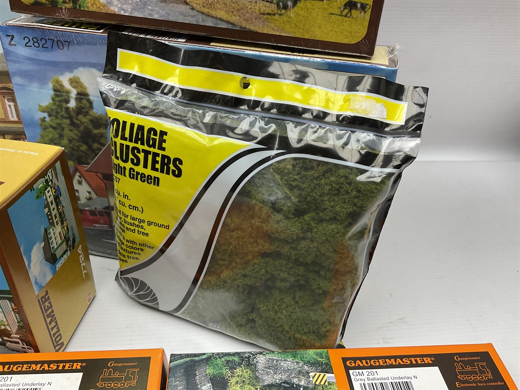 'N' gauge trackside accessories - seven Faller buildings and bridges etc Nos.N212113, N222121, N222583, N222174, N222128, Z282730 & Z282707; two others by Vollmer Nos.N7657 & N7724; four boxes of Gaugemaster Ballasted Underlay; grit and Foliage Clusters