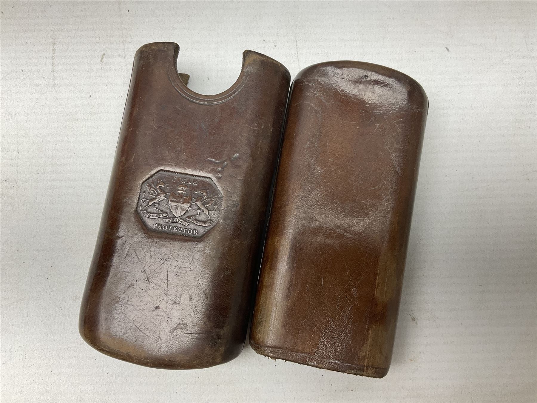 Victorian leather cigar protector with metal match striking plate on the end and internal spring to hold the cigars in place; expands for differing lengths of cigar, minimum L12.5cm; another similar leather cigar case marked Middlemore's Patent with attached vesta case and striker; three Bryant & Mays tin-late matchbox holders including 1935 Jubilee; and small box of matches (6)