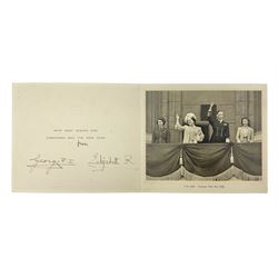 King George VI and Queen Elizabeth - signed 1945 Christmas card with gilt embossed crown to cover, black and white photograph to the interior, of The Royal Family waving from the balcony of Buckingham Palace, on V-E Day Tuesday May 8th 1945, signed 'George R.I. Elizabeth R.'