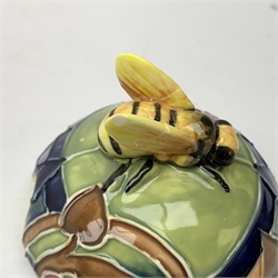 An Old Tupton Ware honey pot, of oval form with tube lined tendril decoration, the domed cover surmounted by a honey bee, with accompanying spoon, together with a pair of Old Tupton Ware vases, with tube lined sunflower decoration, H22cm, each with printed mark to base.
