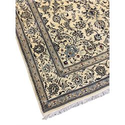 Central Persian Nain rug, wool with silk inlay, ivory ground decorated with scrolling and interlaced branch with stylised plant motifs, central floral medallion, triple band border with repeating design