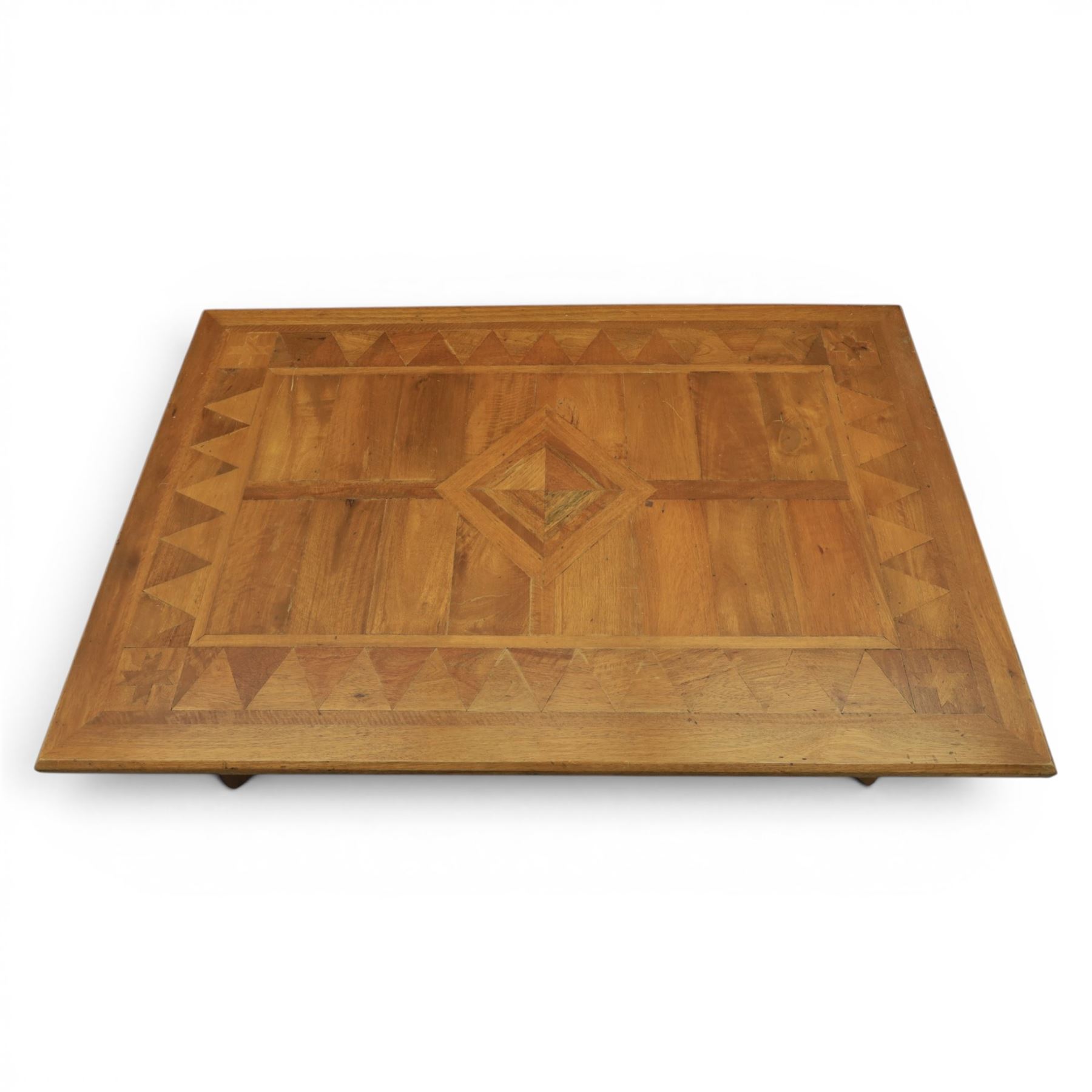 20th century Spanish design oak coffee table, rectangular parquetry top with geometric star and triangular inlaid decoration, moulded edge, on shaped trestle end supports united by black painted wrought iron scroll stretchers