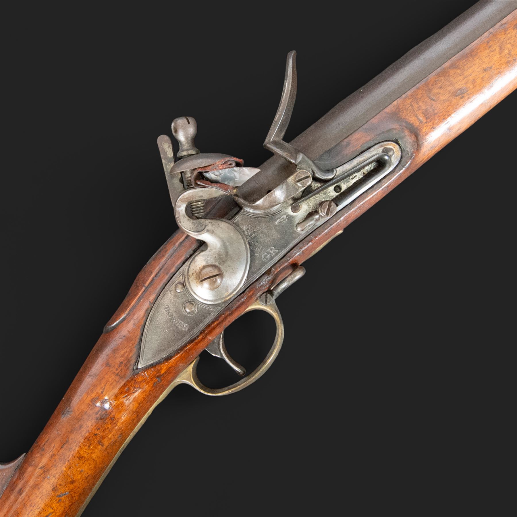 Brown Bess flintlock musket, 37in barrel, action marked with crowned GR and Tower, with brass mounts, the thinned butt marked 38, sling swivels, steel ramrod, overall L132cm
