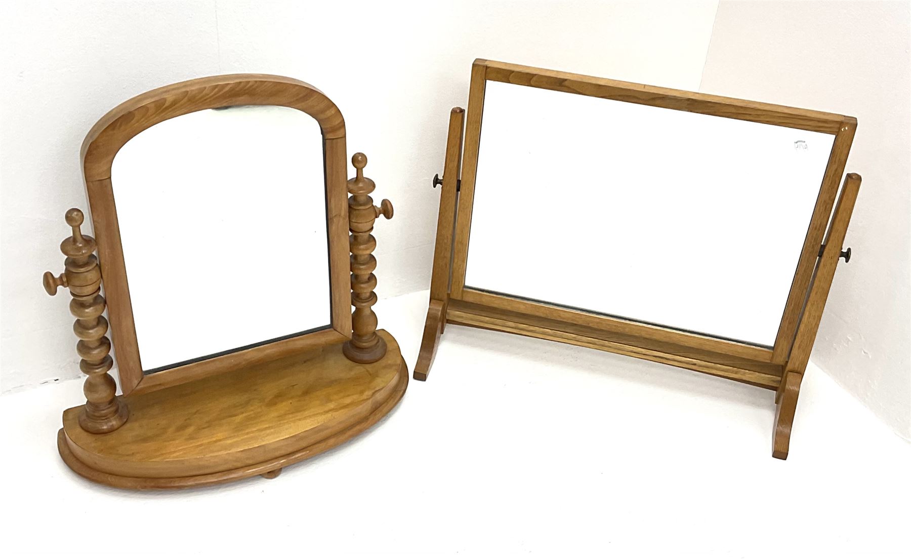 A Victorian satin walnut dressing table swing mirror, with turned supports and curved base, H57cm, together with another later oak example, H52cm.