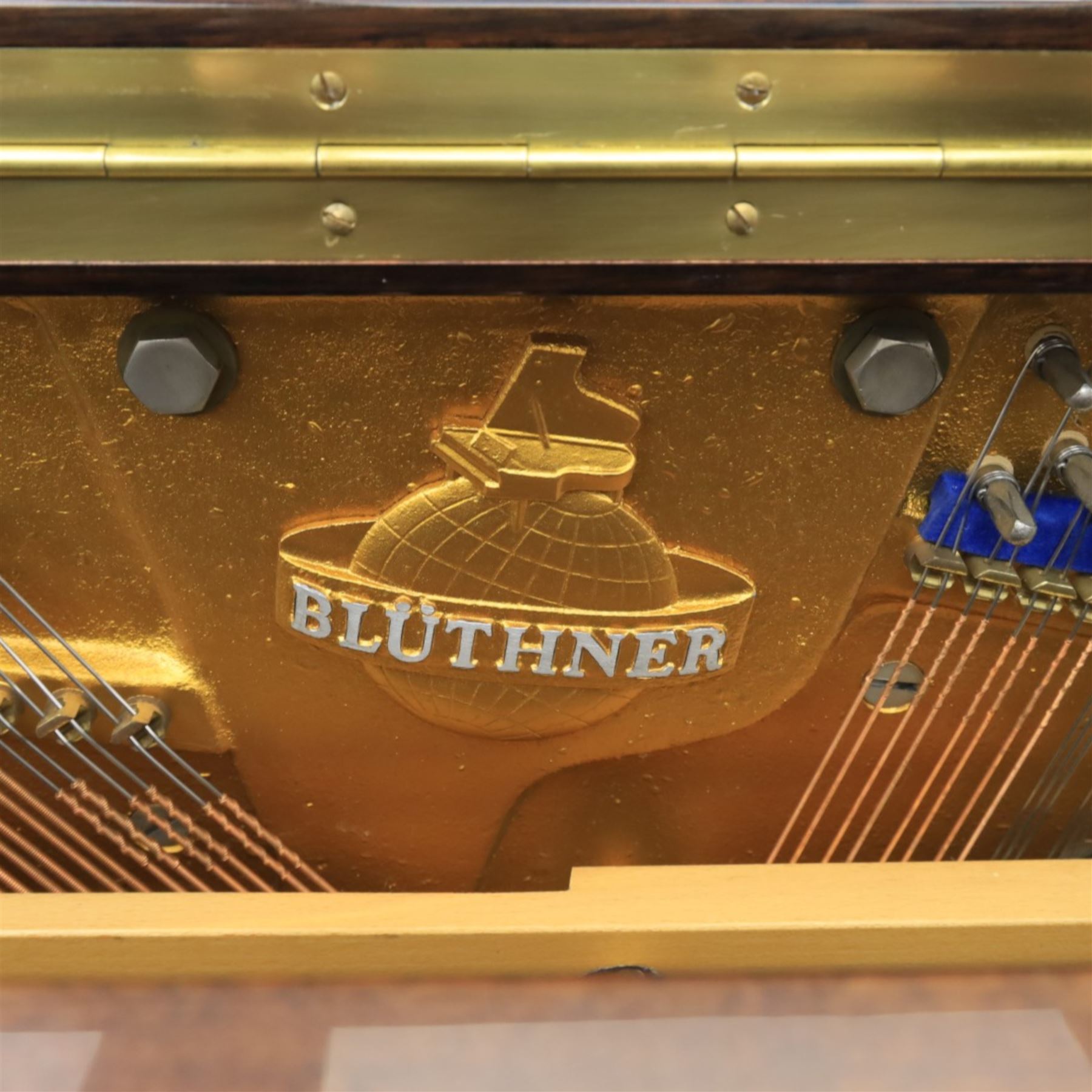 Bluthner of Leipzig upright piano, mahogany case with 88 keys and three brass pedals