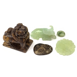 A Chinese carved celadon jade model of an Oxen in recumbent pose, 7.5cm, together with a celadon jade dish carved with a fish, a small jade pebble, a soapstone model of a foo dog, and a jade pendant. 