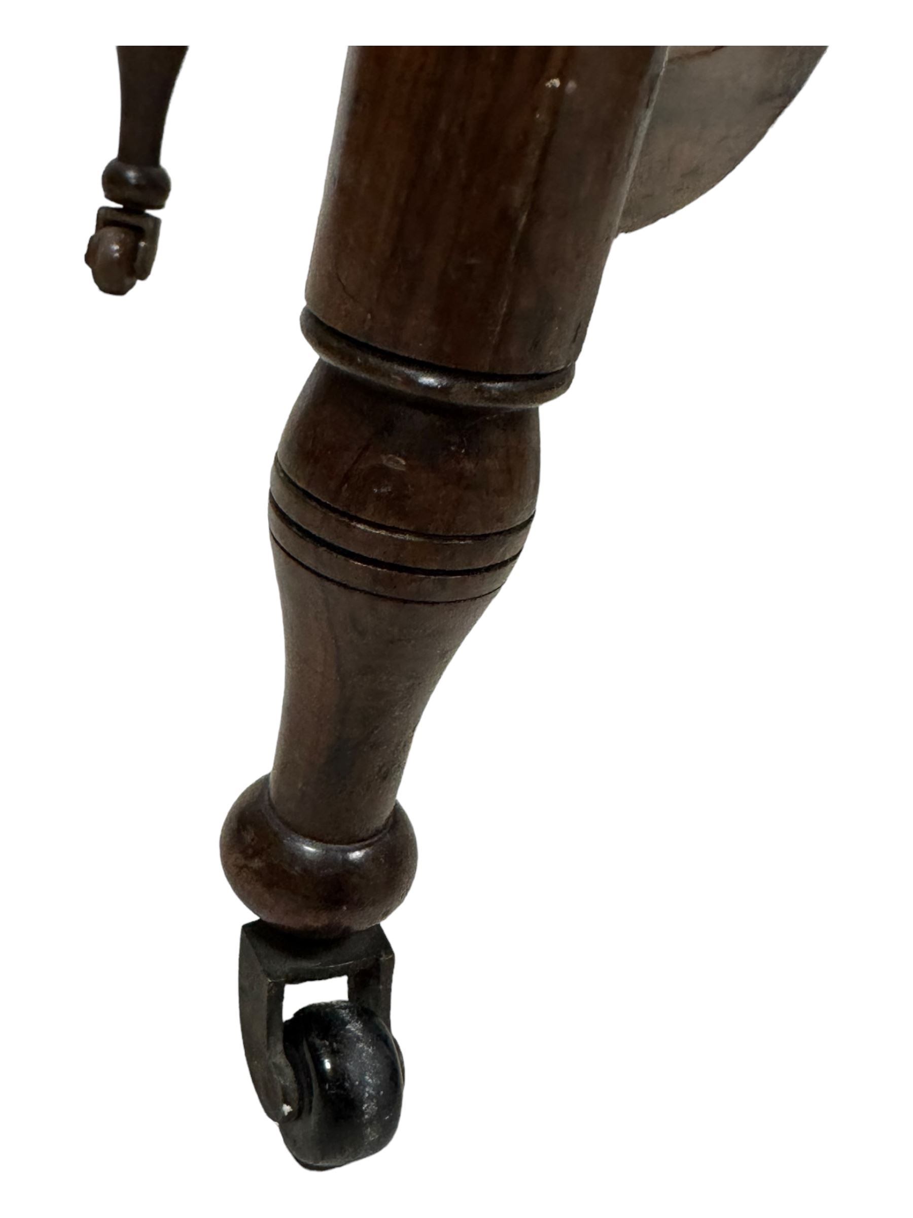 Late Victorian walnut writing table, rectangular leather-inset top surmounted by a brass gallery, fitted with a single frieze drawer, raised on turned tapering supports with lower undertier and ceramic castors