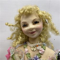 Anna Meszaros Hungary - three hand made needlework figurines - 'The Cobbler' as a child seated in a wooden rocking chair working on a removed boot H28cm; young girl in a long floral dress standing playing a harp H35cm; and young girl wearing a blue tabard standing playing a lute (3) Auctioneer's Note: Anna Meszaros came to England from her native Hungary in 1959 to marry an English businessman she met while demonstrating her art at the 1958 Brussels Exhibition. Shortly before she left for England she was awarded the title of Folk Artist Master by the Hungarian Government. Anna was a gifted painter of mainly portraits and sculptress before starting to make her figurines which are completely hand made and unique, each with a character and expression of its own. The hands, feet and face are sculptured by layering the material and pulling the features into place with needle and thread. She died in Hull in 1998.  