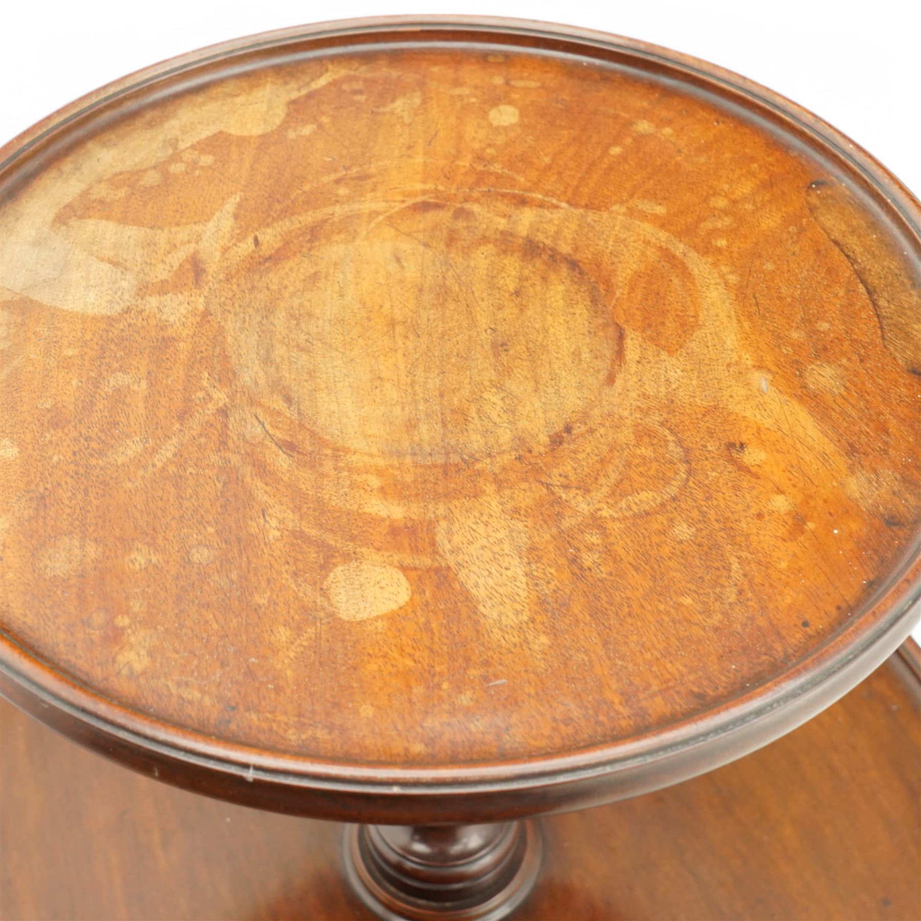 George III mahogany dumb waiter, three graduating circular tiers with moulded edges, turned column supports on tripod base, on castors 
