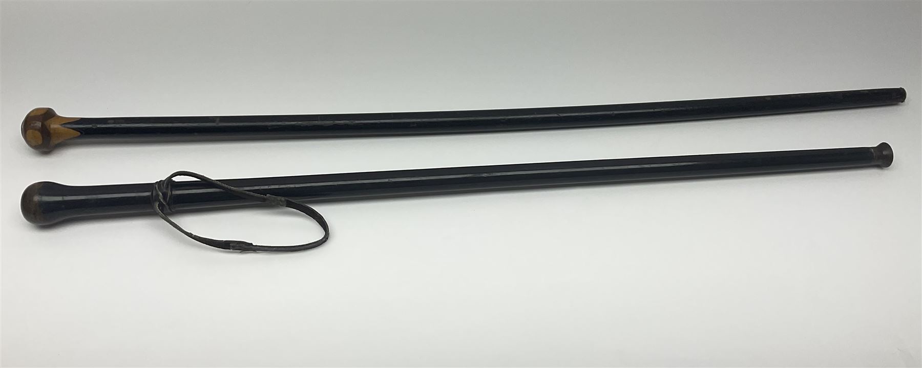 Two ebonised walking sticks, one with 'Leeds City Police' embossed top, tallest H92cm