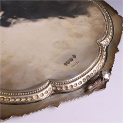 Late Victorian silver salver, of lobed circular form, with foliate beaded rim and engraved floral decoration to centre, upon three claw and ball feet, hallmarked Martin, Hall & Co Sheffield 1896, D26cm