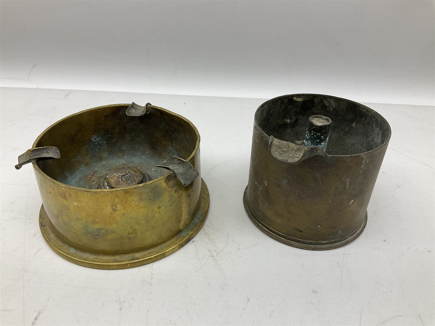 Trench Art - three WW2 brass shell case ashtrays, one mounted with Royal Artillery cap badge and button and one mounted with RA button; together with a pair of place name holders each formed from a Royal Artillery cap badge (5)