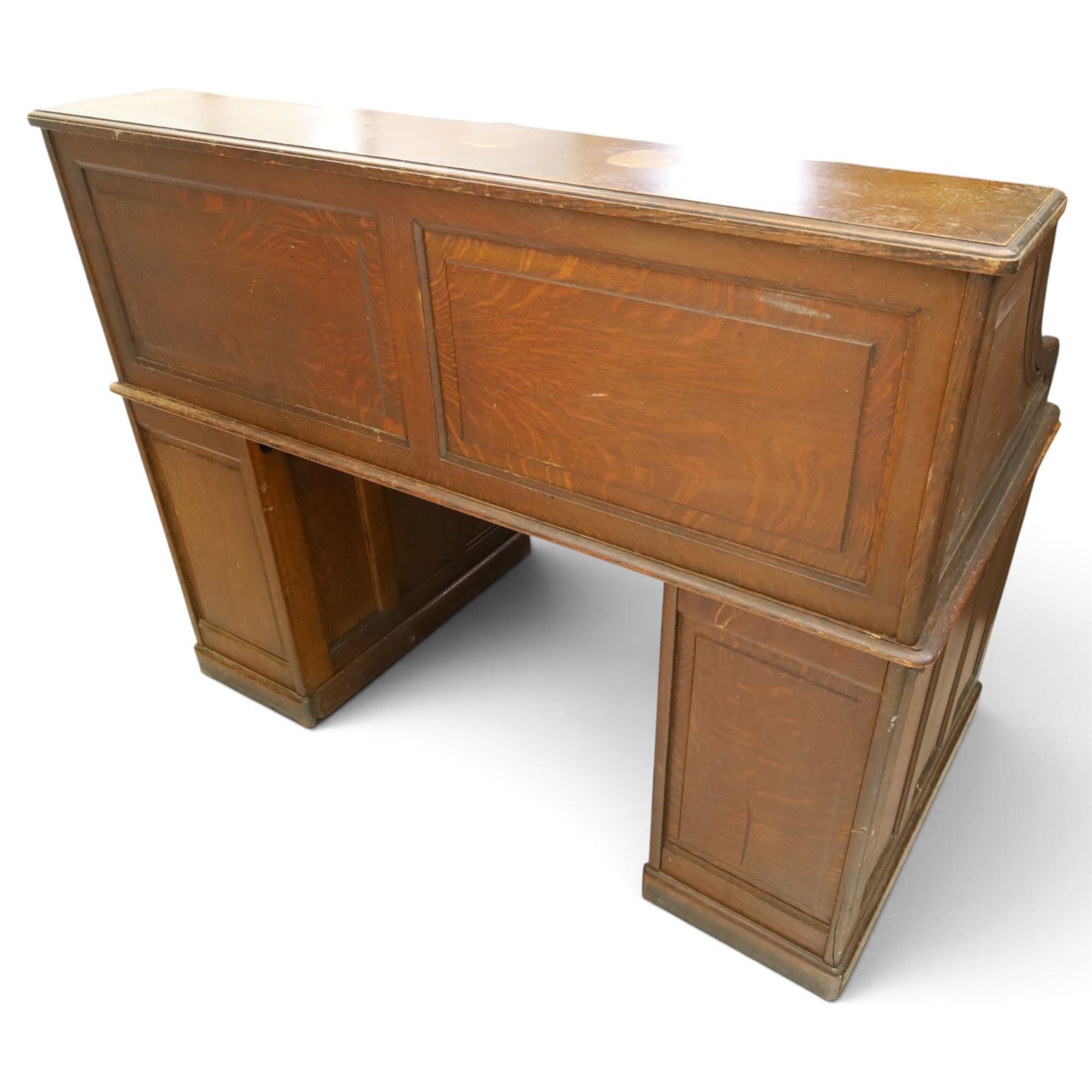 Cutler - Late Victorian oak pedestal tambour desk, the tambour shutter enclosing fitted interior, pull-out writing surface over central kneehole flanked by two pedestals each fitted with four drawers with moulded fronts, pull-out slides above, panelled sides, on moulded plinth base