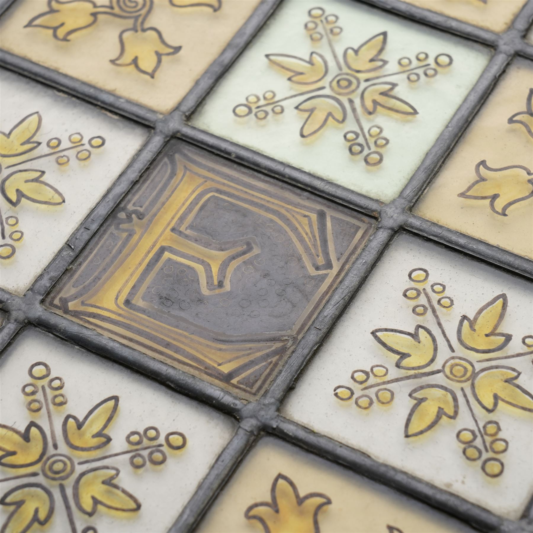 Edwardian stained glass panel, with central painted E motif surrounded by flowers and Yorkshire roses, H47cm