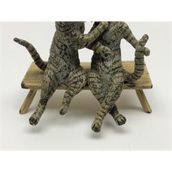 After Bergmann, two cold painted bronze figures, the first modelled as two cats on a bench hugging, the second a cat caning a kitten