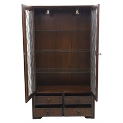 Mid 20th century oak display cabinet, the moulded rectangular cornice above a pair of leaded glazed doors with diamond lattice glazing, enclosing adjustable shelving, the lower section fitted with four short drawers with brass ring handles, flanked by chamfered uprights with carved leaf detail
