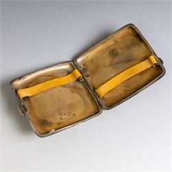 Two early 20th century silver cigarette cases, comprising a rectangular example with foliate decoration and vacant shield cartouche and a 1920s example with engine turned decoration and engraved initials, both hallmarked