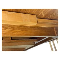 Contemporary light oak round extending dining table with four chairs, table has fold out leaf attached underneath on four out-swept legs, Oak chairs with straight top rail over twin slat back with pierced motifs, brown leather seat with brass studs, square legs joined by plain stretcher 