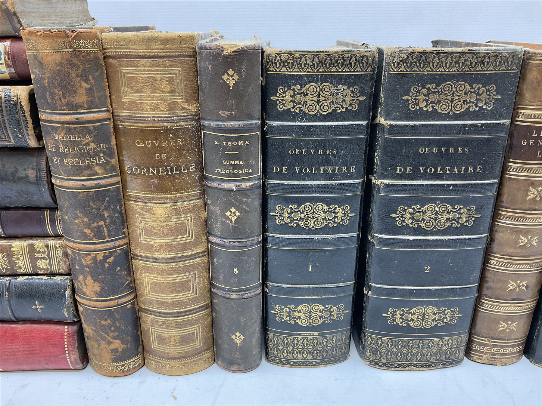 Eighteen 19th century leather bound books including Oeuvres Completes De Voltaire. 1827 Paris. Two volumes; Oeuvres De Pierre Corneille. 1892 Paris; Commentarium in Librum Geneseos Scripsit Thomas Josephus Lamy. 1883 Mechliniae; etc (18)
