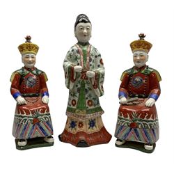 Pair of Chinese figures of Qing Dynasty style Emperors, each Emperor modelled seated upon Chinese garden seats and dressed in traditional red tunic with beaded necklace and elaborate headdress, both with seal marks beneath, together with a further female figure, tallest H36cm