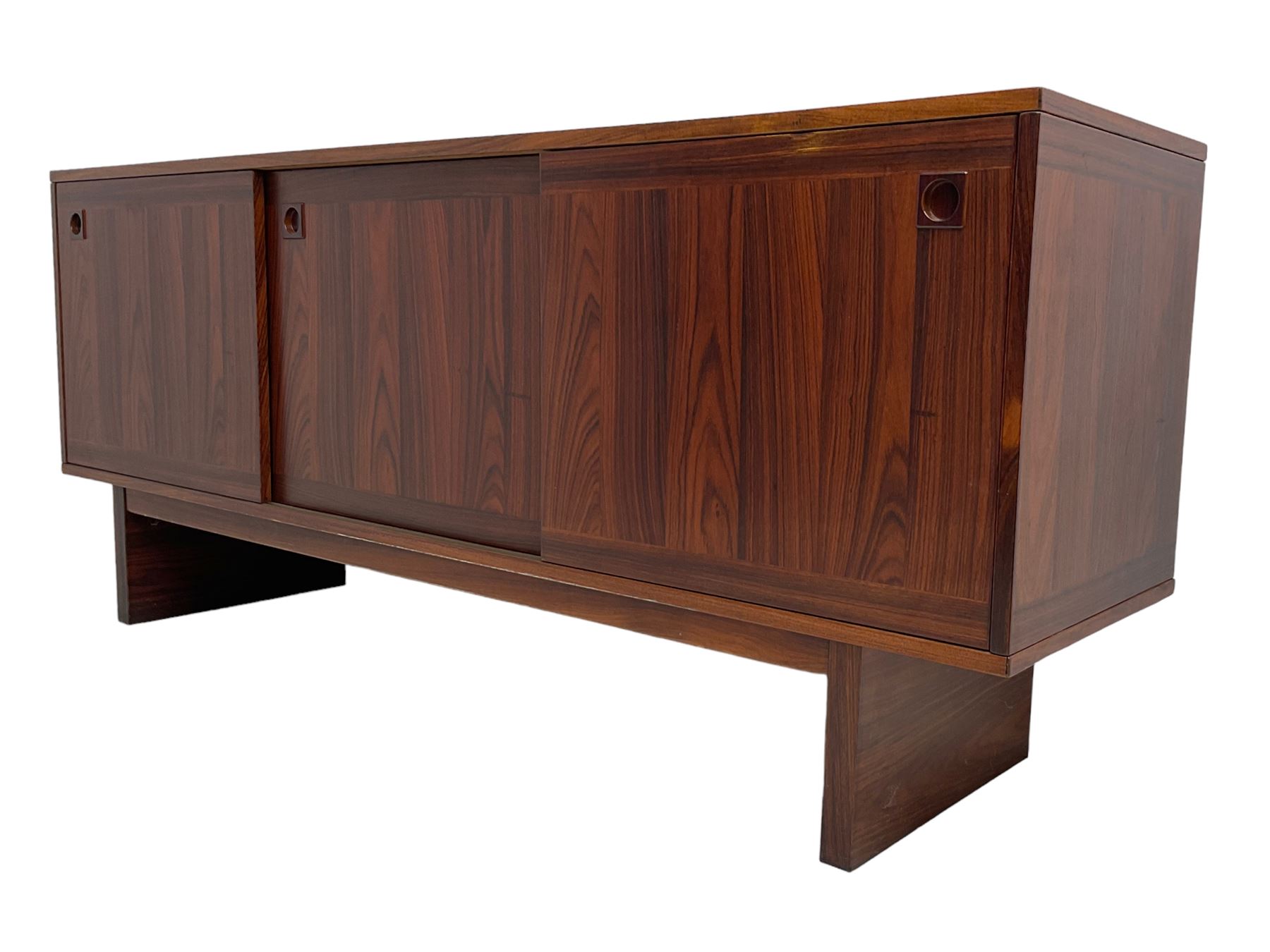 NH Chapman & Co Siesta - mid-20th century sideboard, fitted with three sliding doors, enclosing two drawers and shelves, raised on twin end supports