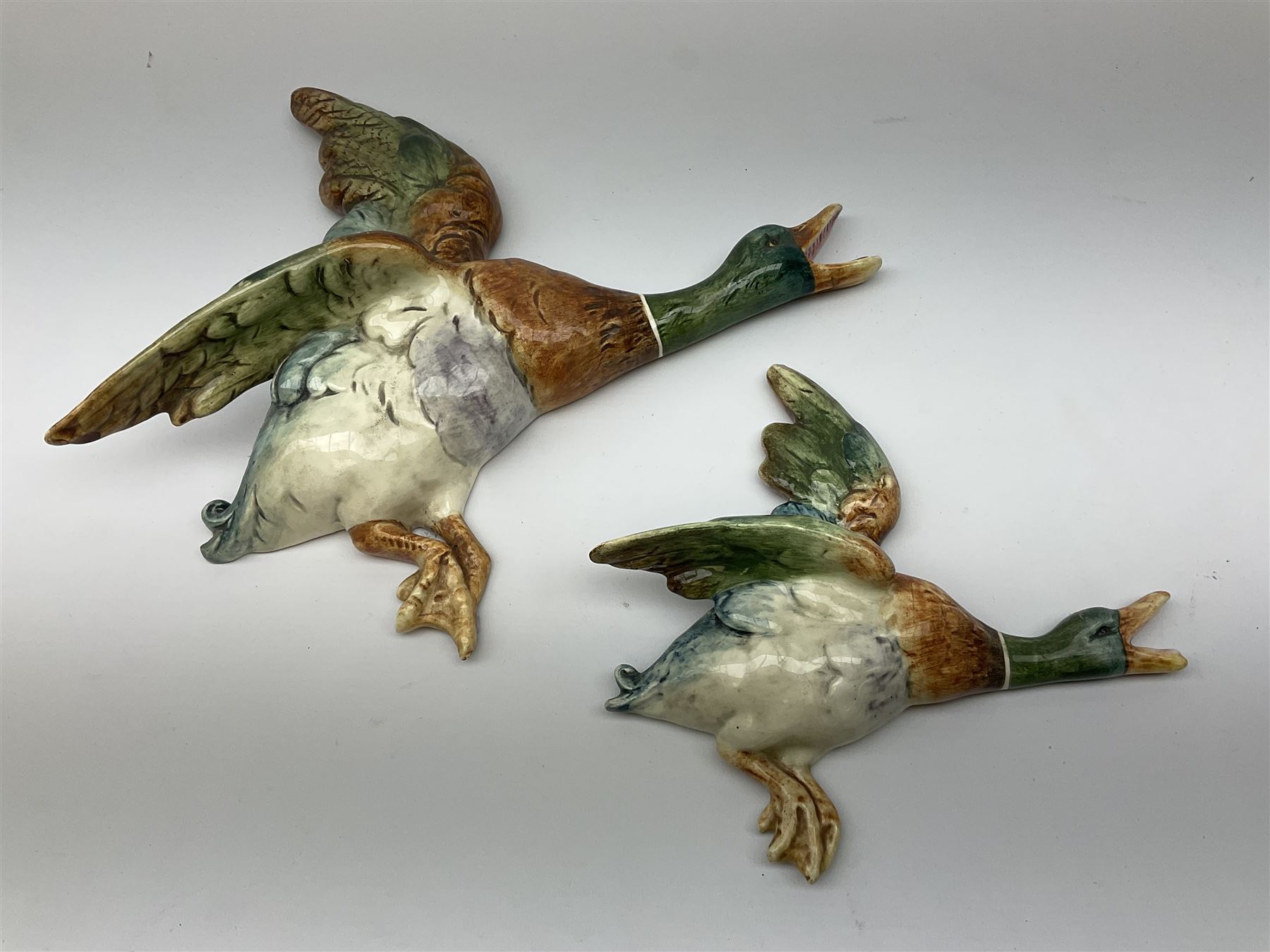 Two Royal Dux wall mounted ducks in flight, both with printed marks verso detailed Made In Czechoslovakia, and impressed marks, largest example L32.5cm, smallest example L21.5cm. 