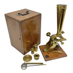 Brass binocular microscope, in a wooden carry case, with various attachments and slides 