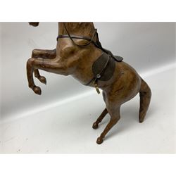 Leather covered horse figure, together with carved wood rhinoceros figure and cat modelled stretching, horse 41cm (3)