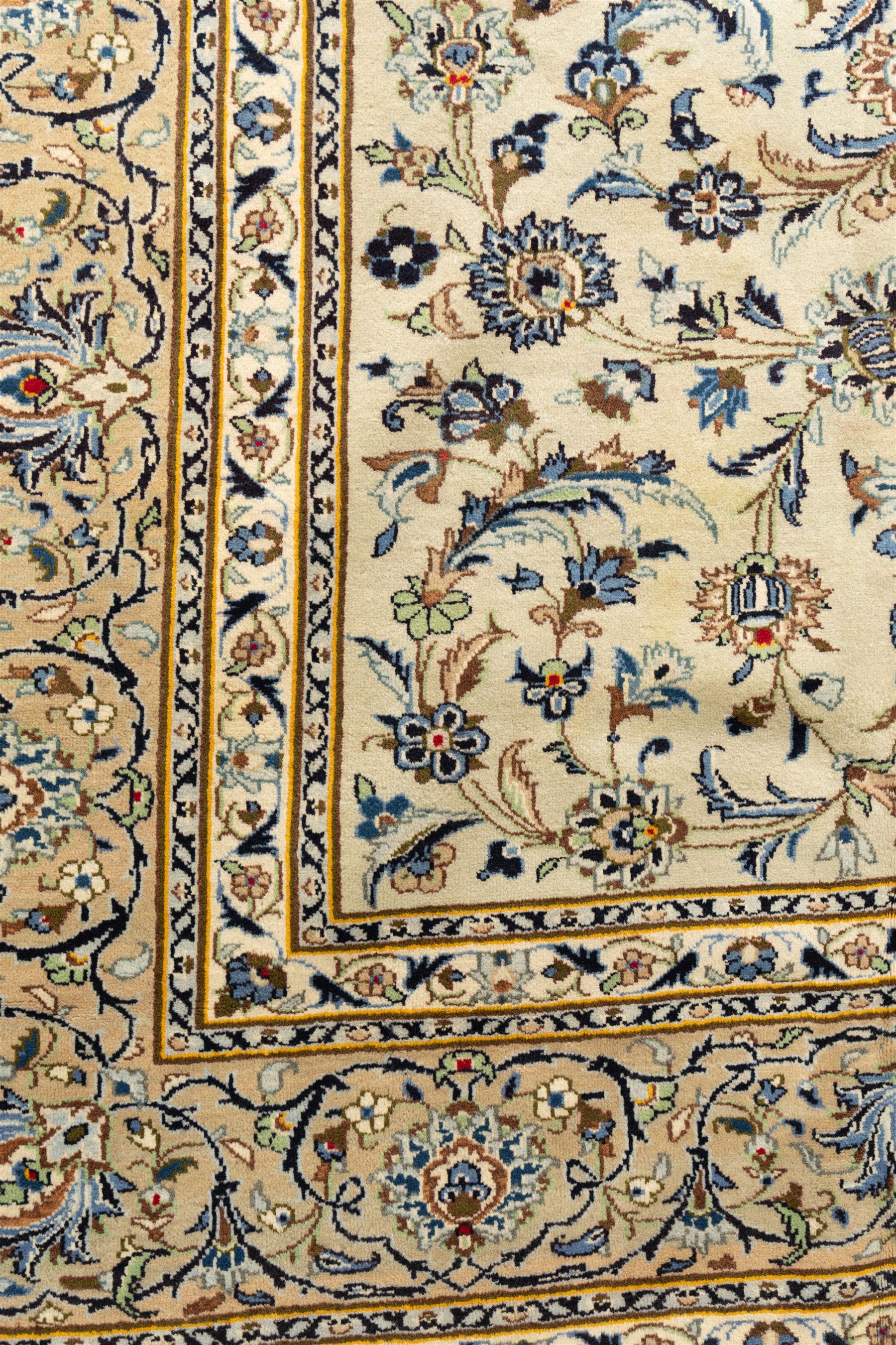 Central Persian Kashan hand-knotted rug, ivory field intricately decorated with an all-over design of scrolling vines, palmettes, and stylized lotus motifs in shades of soft blue, pale gold, and indigo within floral borders