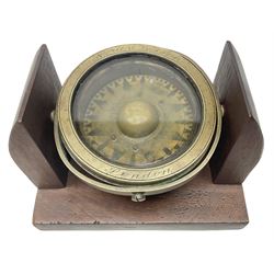Ship's brass compass by Norie & Wilson, London; later mounted on a gimbal in a mahogany display cradle; diameter of compass 15cm; length of base 23cm