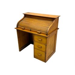Leeway - late 19th century light oak child's roll-top desk, tambour top opening to reveal fitted interior with green felt writing surface and five pigeonholes, over three graduated drawers on the right side, raised on panelled side supports