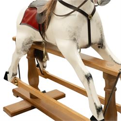 Late 20th century polychrome painted rocking horse, modelled in dapple grey finish with real hair mane and tail, leather tack and saddle, stirrups, raised on a natural wood safety trestle base