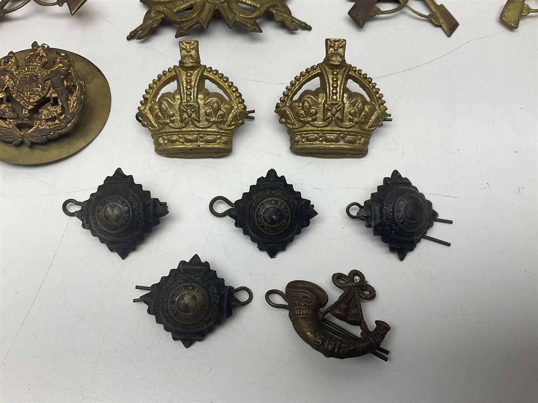 Over thirty British and Continental military metal badges; together with quantity of shoulder titles, collar dogs, rank pips, uniform buttons etc