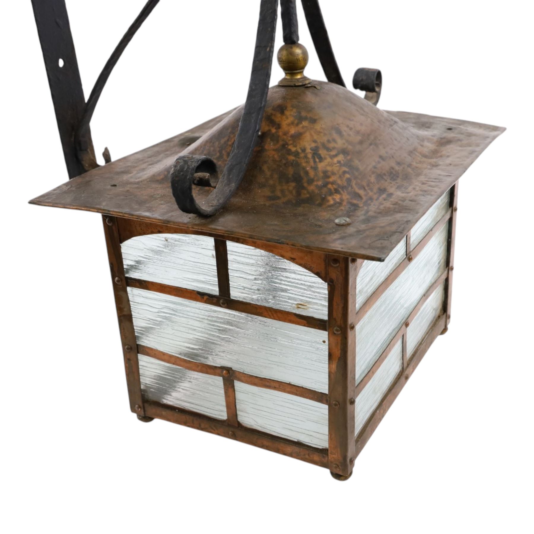 20th century, Arts and Crafts style copper porch lantern, of rectangular form, with cast iron scrolling wall fittings