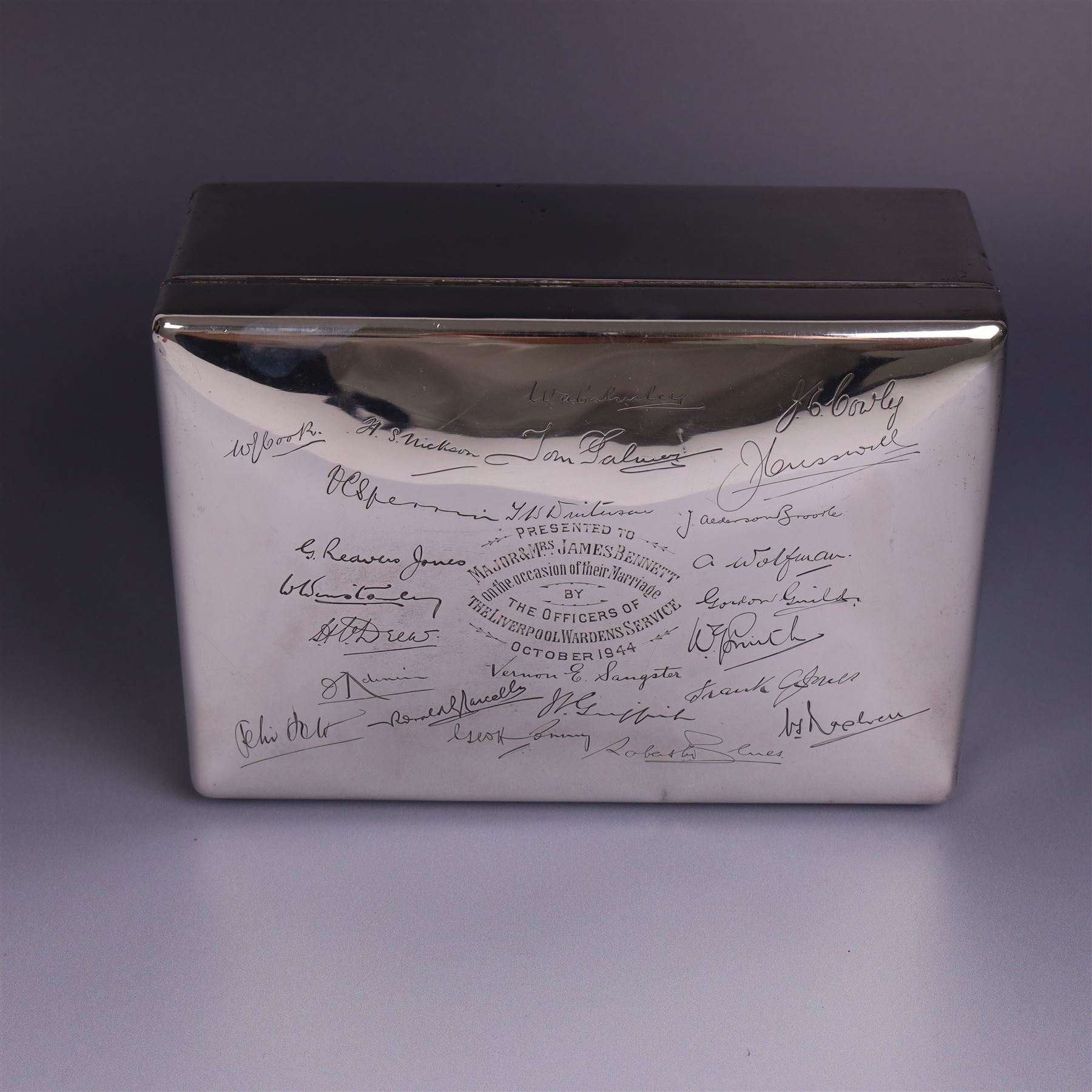 WWII silver mounted cigarette box, of rectangular form, the hinged cover inscribed 'presented to Major & Mrs James Bennett on the occasion of their marriage by the officers of the Liverpool Wardens Service October 1944' and engraved with twenty-four signatures of the officers, with softwood interior, hallmarks worn and indistinct, H7.5cm, W19cm