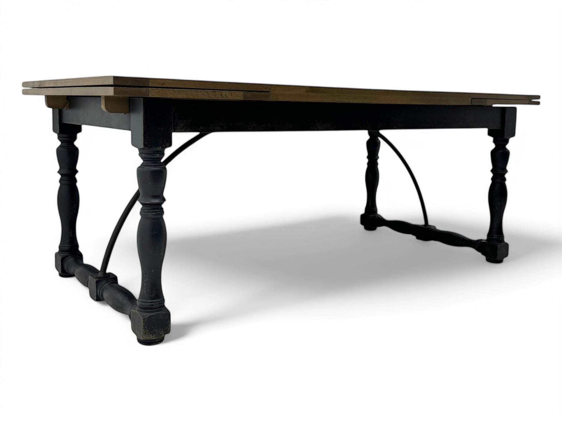Barker & Stonehouse - large oak extending draw-leaf dining table, rectangular plank top over a black painted base, turned supports joined by shaped stretchers, extending at each end with pull-out leaves