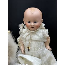 Two German bisque head dolls, to include a Franz Schmidt example with blue glass eyes and an Armand Marseille 590 example with applied hair, together with a Schoenau & Hoffmeister bisque doll's head, pair of doll's hands and a collection of clothing