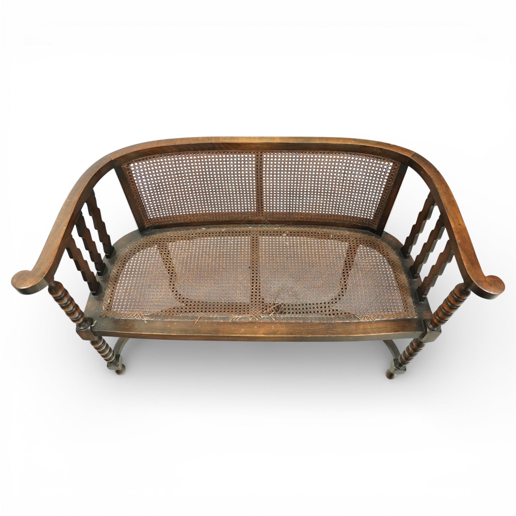 20th century bergère two seater settee, with shaped curved top rail and downswept arms, the back and seat fitted with woven cane panels, supported by turned uprights and legs united by a carolean stretcher 