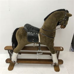 Rocking horse with leather saddle and reins on stained wooden trestle base
